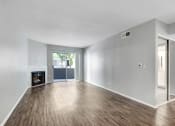 Thumbnail 44 of 61 - an empty living room with a fireplace and wooden floors