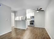 Thumbnail 18 of 61 - an empty living room and kitchen with a ceiling fan