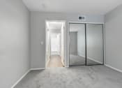Thumbnail 53 of 61 - an empty bedroom with mirrored closet doors and a carpeted floor