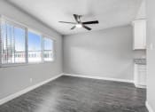 Thumbnail 23 of 52 - an empty living room with a ceiling fan and a window