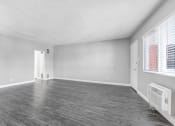 Thumbnail 26 of 52 - the living room of an empty apartment with wood flooring and a large window