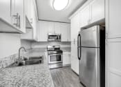 Thumbnail 20 of 52 - a kitchen with white cabinets and stainless steel appliances