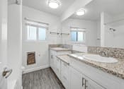 Thumbnail 31 of 52 - a bathroom with white cabinets and granite counter tops