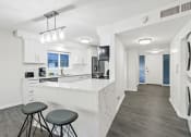 Thumbnail 90 of 135 - a kitchen with a bar and stools in a house
