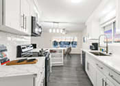 Thumbnail 85 of 135 - a kitchen with white cabinets and marble counter tops and a sink