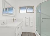 Thumbnail 95 of 135 - a bathroom with a shower and a sink and a mirror