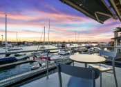 Thumbnail 78 of 135 - a view of a marina at sunset from a balcony with a table and chairs