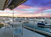 Thumbnail 81 of 135 - a balcony overlooking a marina with boats and a sunset