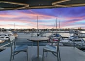 Thumbnail 80 of 135 - a view of a marina with boats in the water and a patio with chairs