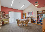 Thumbnail 41 of 52 - a library with a table and chairs and shelves of books