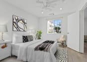 Thumbnail 25 of 52 - a white bedroom with a bed and a ceiling fan