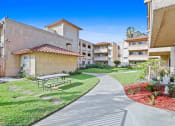 Thumbnail 38 of 52 - a picnic table sits on a sidewalk in front of an apartment building