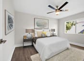 Thumbnail 12 of 22 - A bedroom with a white bed and a ceiling fan.