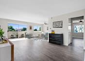 Thumbnail 5 of 22 - A living room with a white wall and a black dresser.