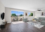 Thumbnail 2 of 22 - A living room with a grey couch, a television, and a fan.