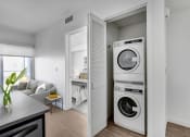 Thumbnail 23 of 83 - a living room with a washer and a dryer in it