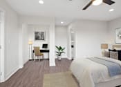 Thumbnail 16 of 22 - A bedroom with a large bed and a desk with a chair.
