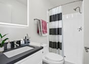 Thumbnail 17 of 22 - A white toilet sits next to a sink in a bathroom.