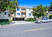 Thumbnail 6 of 19 - A car is parked on the street in front of a building with a sign that reads "The Oasis.".