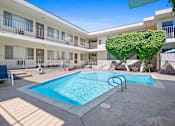 Thumbnail 5 of 19 - A pool in a courtyard surrounded by a white building.