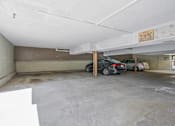 Thumbnail 8 of 19 - A parking garage with a white ceiling and a sign on the wall.