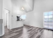 Thumbnail 29 of 62 - an empty living room with a kitchen and a window