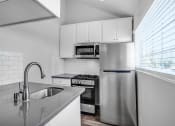 Thumbnail 11 of 62 - a kitchen with a sink and a stainless steel refrigerator