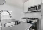 Thumbnail 27 of 62 - a kitchen with a sink and a microwave