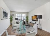 Thumbnail 2 of 16 - a living room with a glass table and white chairs