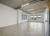Thumbnail 24 of 92 - A large empty room with a concrete floor and ceiling.