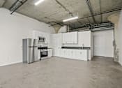 Thumbnail 19 of 92 - A kitchen with white cabinets and a black countertop is shown.