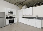 Thumbnail 17 of 92 - A kitchen with white cabinets and appliances.