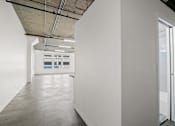Thumbnail 25 of 92 - A white room with a door on the right side.