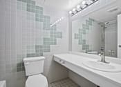 Thumbnail 16 of 92 - A white toilet sits next to a white sink in a bathroom.