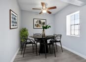 Thumbnail 9 of 16 - a dining room with a table and chairs and a ceiling fan