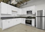 Thumbnail 6 of 92 - A kitchen with white cabinets and stainless steel appliances.