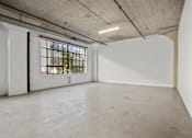 Thumbnail 13 of 92 - A large empty room with a window and a door.