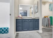 Thumbnail 7 of 16 - a bathroom with blue cabinets and a gray rug