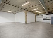 Thumbnail 12 of 92 - A large empty room with a concrete floor and white walls.