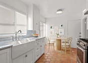 Thumbnail 9 of 17 - a kitchen with a sink and a table with chairs