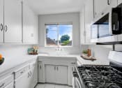 Thumbnail 12 of 35 - a kitchen with white cabinets and a window