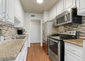 Thumbnail 1 of 20 - a kitchen with granite counter tops and stainless steel appliances