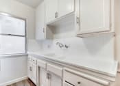 Thumbnail 1 of 5 - a kitchen with white cabinets and a window
