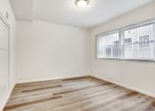 Thumbnail 4 of 5 - a bedroom with hardwood floors and a large window