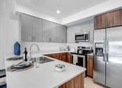 Thumbnail 2 of 83 - a kitchen with stainless steel appliances and a white counter top