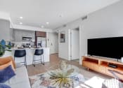 Thumbnail 4 of 83 - a living room with a tv and a kitchen in the background