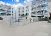 Thumbnail 13 of 83 - an apartment building with a fence and a pool in front of it