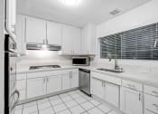 Thumbnail 12 of 16 - a white kitchen with white cabinets and a sink