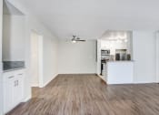 Thumbnail 3 of 23 - the living room of an apartment with a kitchen and a ceiling fan
