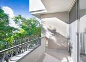 Thumbnail 8 of 23 - a balcony with a door and a view of a tree